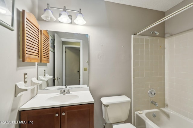 full bathroom featuring toilet, vanity, a textured ceiling, and tiled shower / bath combo