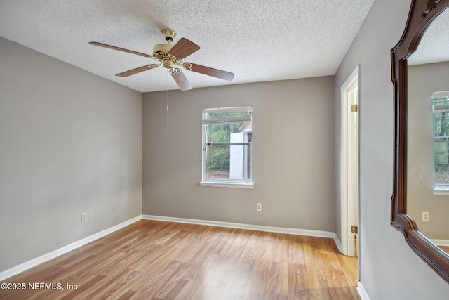 spare room featuring a textured ceiling, ceiling fan, and light wood-type flooring