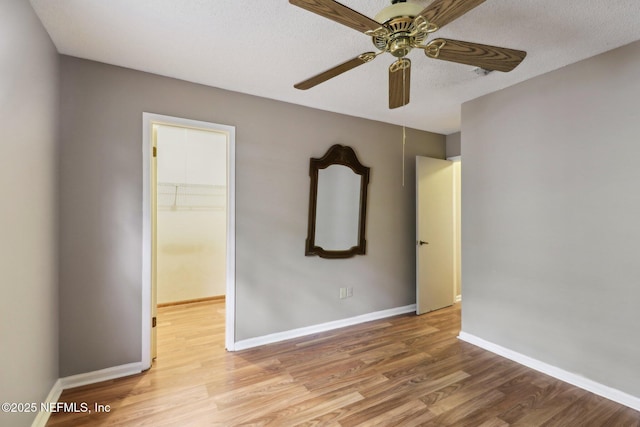 empty room featuring light hardwood / wood-style floors, ceiling fan, and a textured ceiling