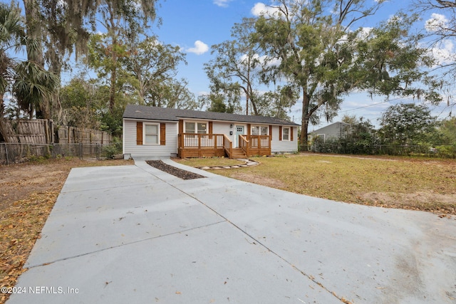 view of front of property with a deck and a front lawn