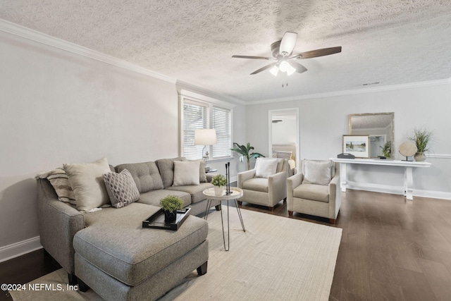 living room featuring ceiling fan, ornamental molding, a textured ceiling, and dark wood-type flooring