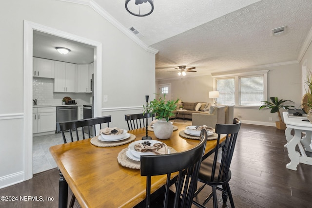 dining space featuring a textured ceiling, ceiling fan, and crown molding