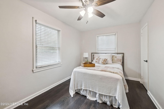 bedroom with multiple windows, ceiling fan, and dark wood-type flooring