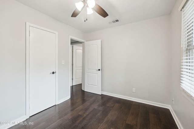 unfurnished bedroom with a closet, ceiling fan, and dark hardwood / wood-style flooring