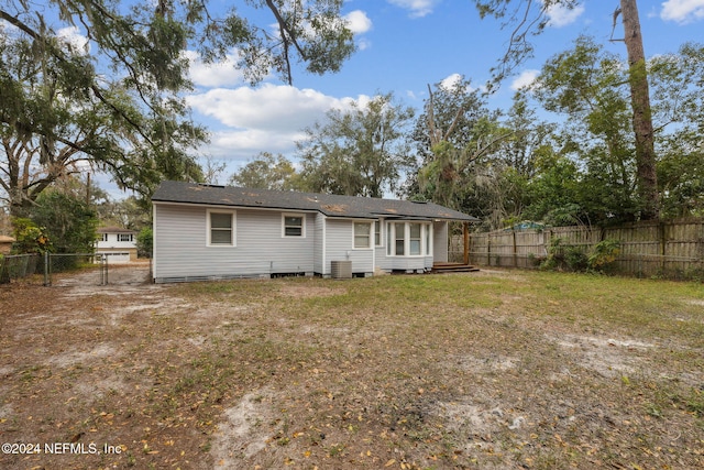 rear view of house with a yard and central air condition unit