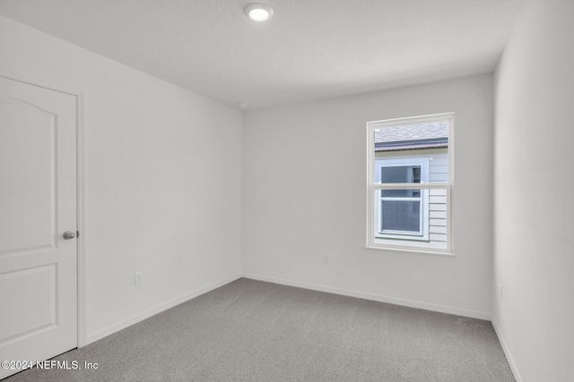 carpeted spare room with a textured ceiling