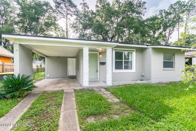 single story home featuring a front lawn and a carport