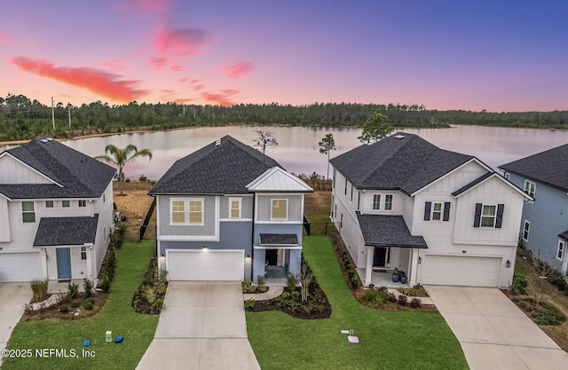 view of front of property featuring a water view, a garage, and a yard