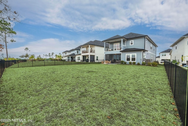 rear view of property featuring a balcony and a lawn