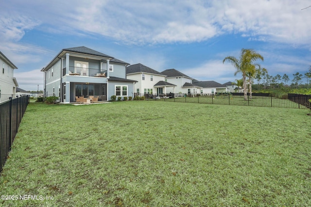 rear view of property featuring a lawn and a balcony