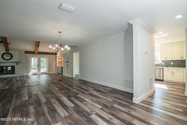 unfurnished living room featuring a fireplace, an inviting chandelier, vaulted ceiling with beams, french doors, and dark wood-type flooring