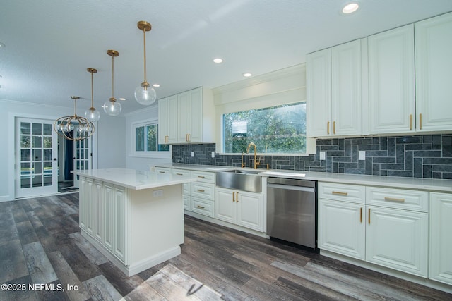 kitchen featuring dishwasher, hanging light fixtures, a center island, sink, and white cabinetry