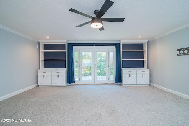 unfurnished living room with french doors, crown molding, built in features, ceiling fan, and light carpet