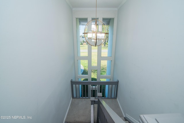 stairs featuring an inviting chandelier, crown molding, and carpet flooring