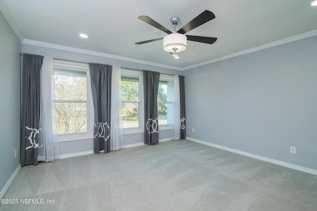 carpeted empty room with ceiling fan, crown molding, and a textured ceiling