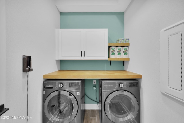 washroom with washer and dryer and cabinets