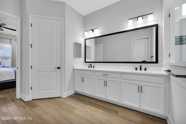 bathroom with wood-type flooring, vanity, and ceiling fan