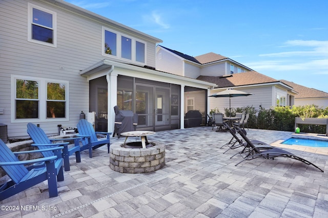 view of patio featuring a sunroom and a fire pit