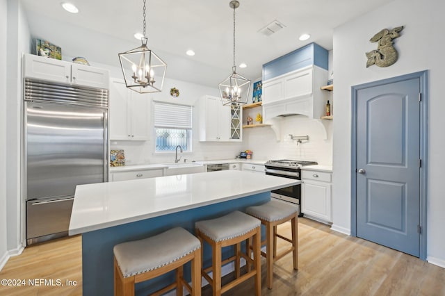 kitchen with white cabinets, a kitchen breakfast bar, a kitchen island, custom range hood, and stainless steel appliances