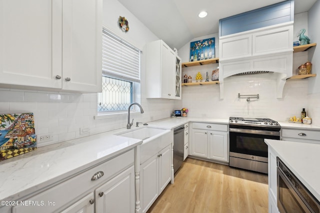 kitchen with light stone countertops, appliances with stainless steel finishes, sink, light hardwood / wood-style flooring, and white cabinetry