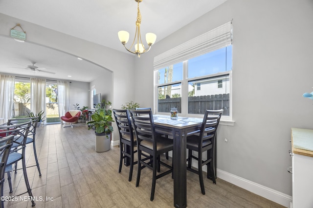 dining area featuring hardwood / wood-style floors and ceiling fan with notable chandelier