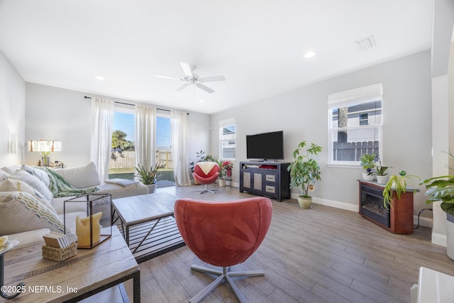 living room with hardwood / wood-style flooring and ceiling fan