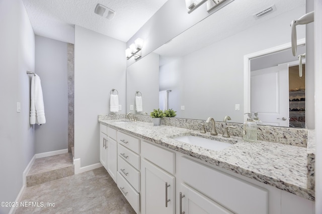 bathroom with vanity and a textured ceiling