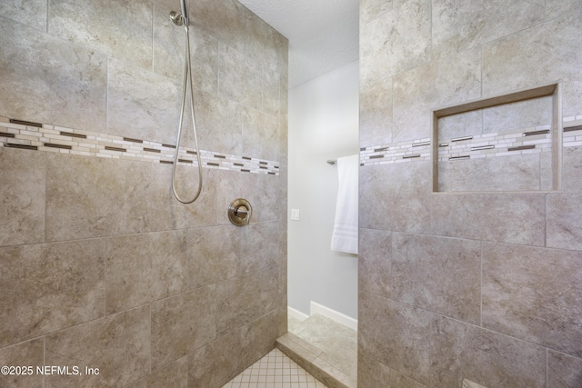 bathroom featuring tile patterned floors and tiled shower