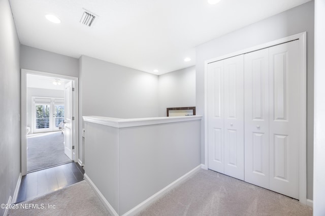 hallway featuring light colored carpet