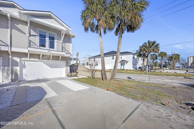 view of side of property featuring a balcony and a garage