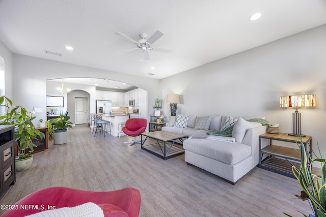 living room featuring light hardwood / wood-style floors and ceiling fan