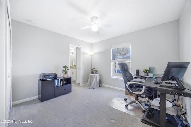 carpeted home office with ceiling fan and a textured ceiling