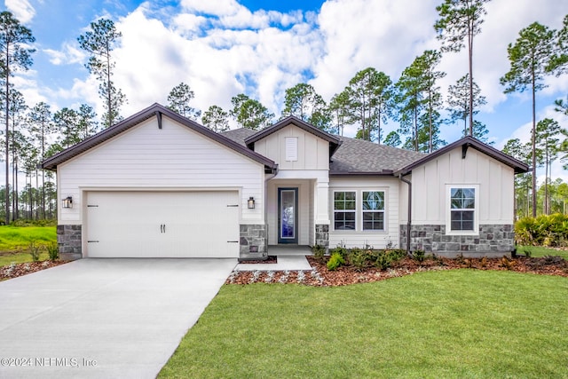 view of front of home with a front yard and a garage