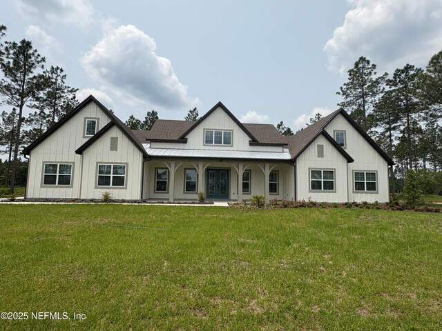 36199 Pitch Ln, Hilliard, FL 32046 - back of property with board and batten siding, a lawn, a shingled roof, and french doors