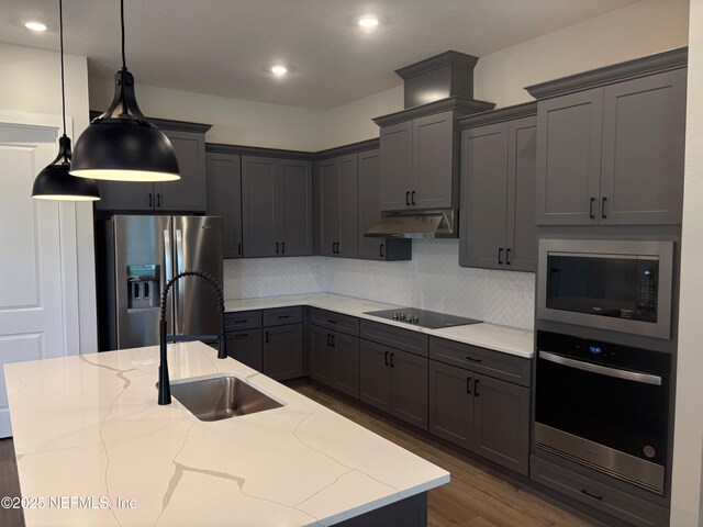 36199 Pitch Ln, Hilliard, FL 32046 - kitchen featuring stainless steel appliances, a sink, light stone counters, backsplash, and recessed lighting
