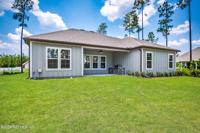 back of property featuring ceiling fan and a yard