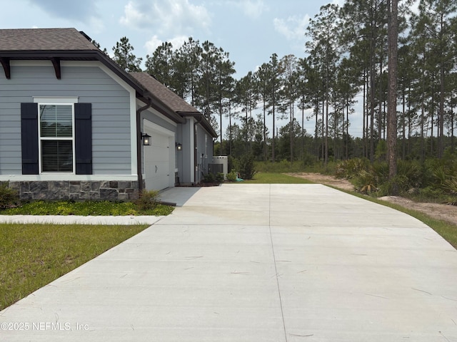 36231 Pitch Ln, Hilliard, FL 32046 - view of property exterior with concrete driveway, a garage, and roof with shingles