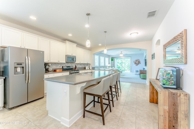 kitchen with pendant lighting, white cabinets, ceiling fan, a kitchen island, and stainless steel appliances