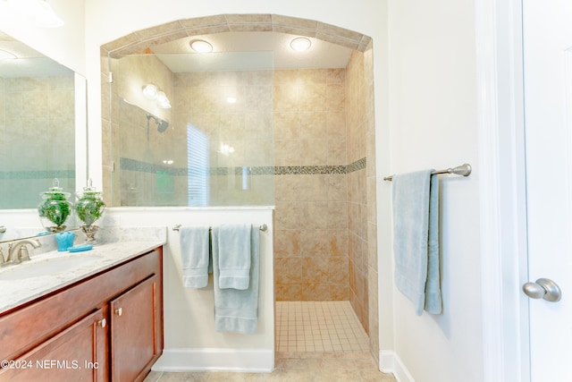 bathroom featuring tile patterned flooring, vanity, and tiled shower