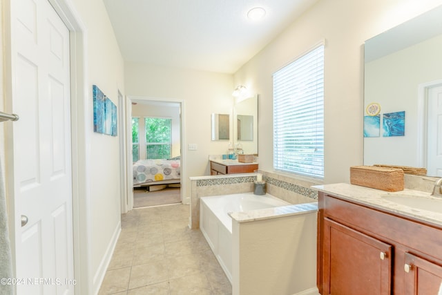 bathroom with a tub to relax in, tile patterned flooring, vanity, and a healthy amount of sunlight