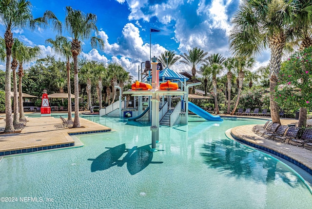 view of swimming pool with a playground and a water slide