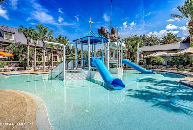 view of pool featuring a playground and a water slide