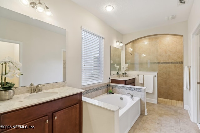 bathroom with tile patterned floors, vanity, a textured ceiling, and independent shower and bath