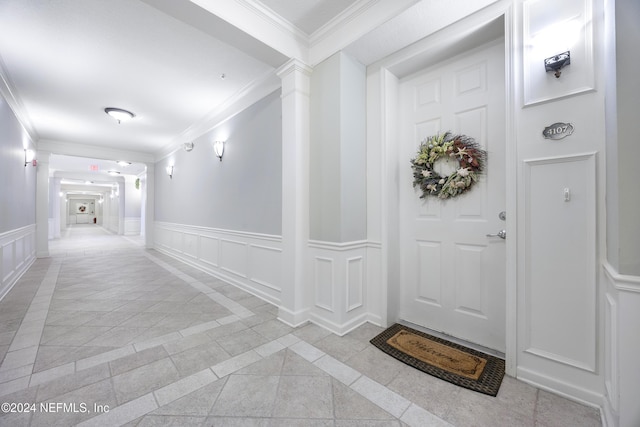 interior space with decorative columns, light tile patterned floors, and ornamental molding