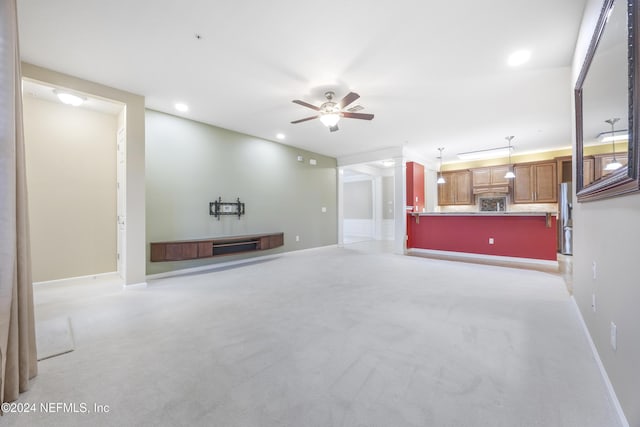 unfurnished living room with ceiling fan and light carpet