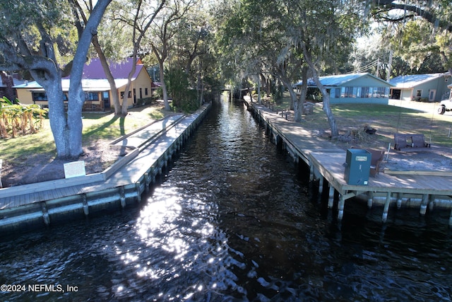 dock area with a lawn and a water view