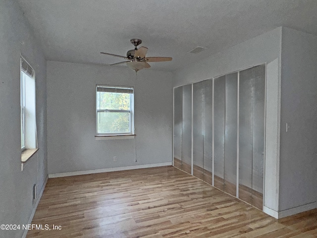 unfurnished room with light wood-type flooring, plenty of natural light, and ceiling fan