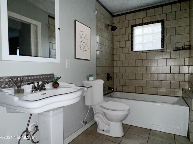 bathroom featuring tile patterned flooring, tiled shower / bath combo, and toilet