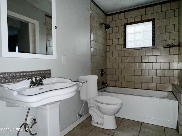 bathroom with tile patterned floors, tiled shower / bath combo, and toilet