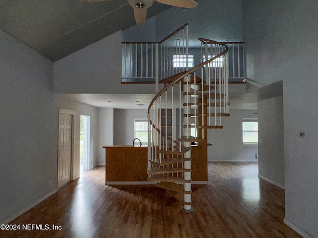 staircase with hardwood / wood-style flooring, vaulted ceiling, ceiling fan, and sink